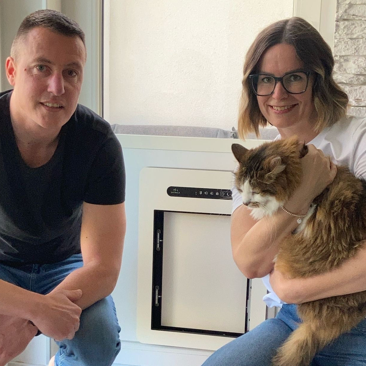 Foto der Familie Nagy mit Ihrer Katze am Arm vor der petWALK Tiertüre, die sie beim Gewinnspiel gewonnen haben.